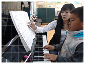 학생에게 피아노 지도하는 모습